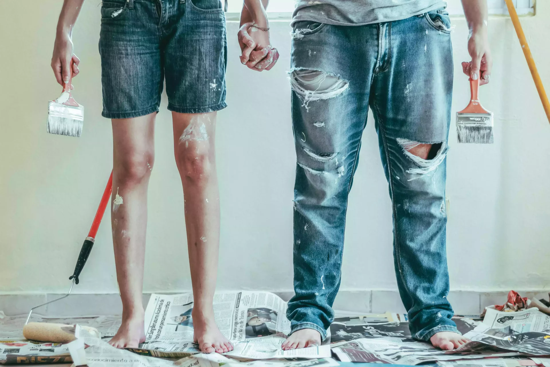 Couple en habit de travaux prêt à peindre un mur